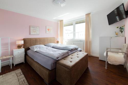 a bedroom with a bed with a ottoman and a window at Ferienwohnung Ostseestübchen in Scharbeutz