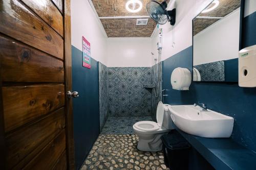a bathroom with a toilet and a sink at Mad Monkey Hostel Siargao in General Luna