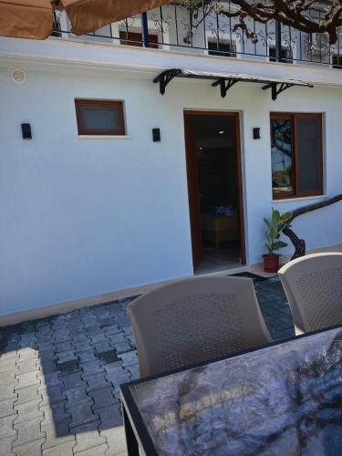 a table and chairs in front of a house at Guest House Mene in Gjirokastër
