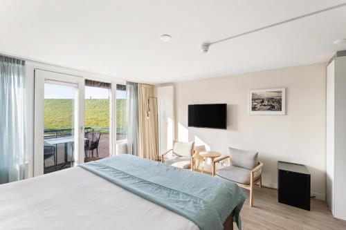 a hotel room with a bed and a balcony at Strandhotel Zoutelande in Zoutelande