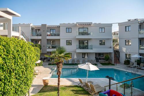 an apartment with a swimming pool and a building at Minos Village in Agia Marina Nea Kydonias