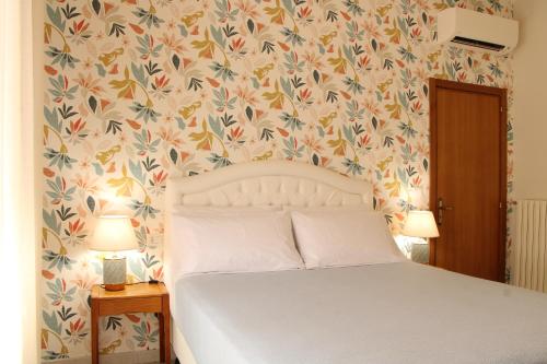 a bedroom with a bed with a flowery wallpaper at Guest House Scarlatti in Battipaglia
