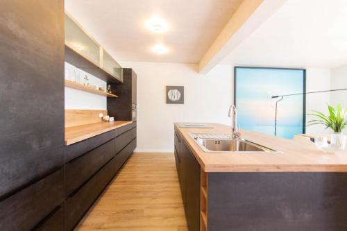 a kitchen with a sink and a large window at Ferienhaus Westside Niendorf in Häven