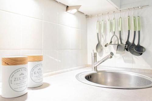 a kitchen counter with a sink and utensils at Ferienwohnung Urlaubsflair in Timmendorfer Strand