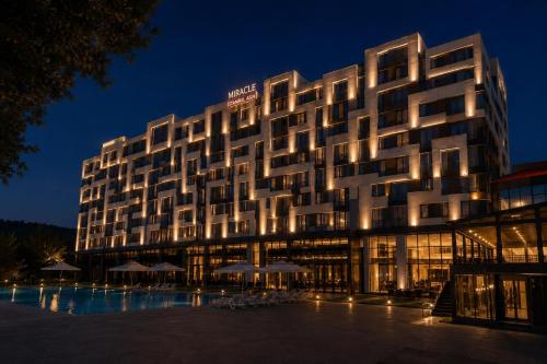 a hotel building with a pool in front of it at Miracle Istanbul Asia Airport Hotel & Spa in Istanbul