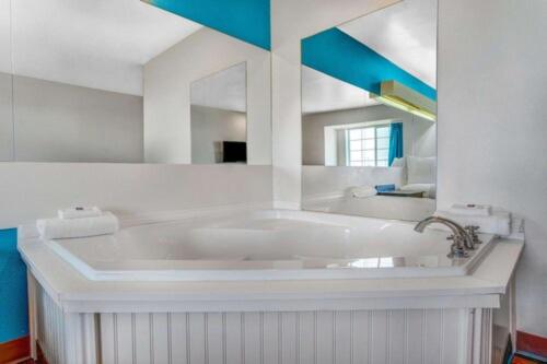 a large white tub in a bathroom with a mirror at Motel 6-Idaho Falls, ID - Snake River in Idaho Falls