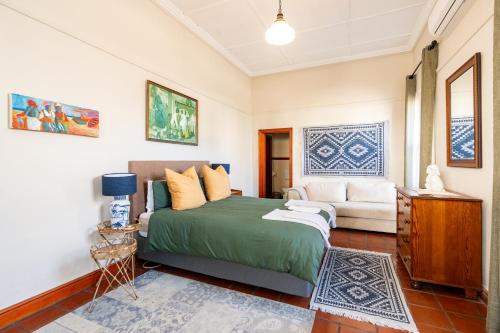a bedroom with a bed and a couch at Elizabeth's Cottage in Montagu