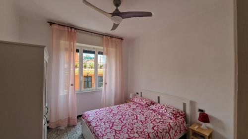 ein Schlafzimmer mit einem rosa Bett und einem Fenster in der Unterkunft Rapallo Riviera in Rapallo