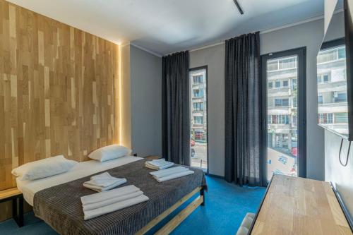 a hotel room with a bed and a large window at O'clock bed & SPA in Burgas