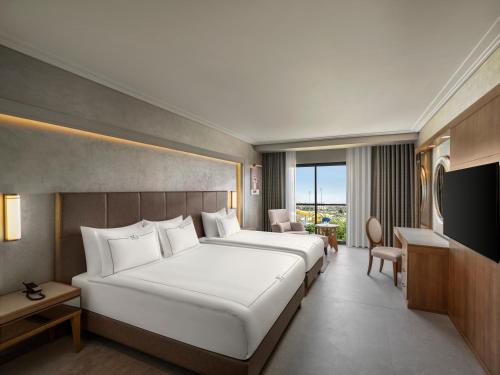 a hotel room with two beds and a television at NG Afyon Wellness & Convention in Afyon