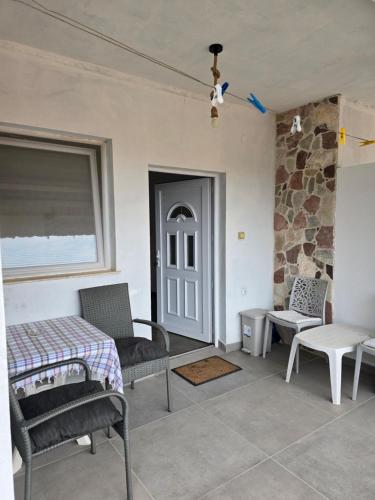 a room with a bed and chairs and a stone wall at Ignjic Apartmani in Buljarica