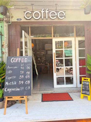 a coffee shop with a sign in front of it at Baan Bangrak Home in Bang Rak
