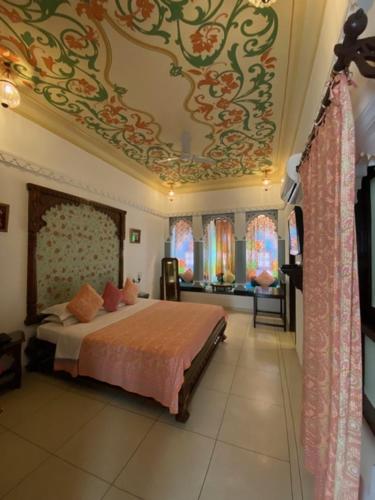 a bedroom with a bed with a painting on the ceiling at Mahendra Prakash in Udaipur