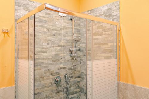 a shower with a glass door in a bathroom at Magnifica Terrazza - Lake View & Wi-Fi in Gardone Riviera