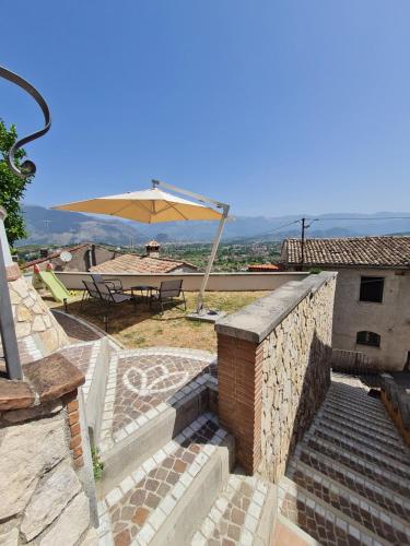 eine Terrasse mit Tisch und Sonnenschirm in der Unterkunft Il Camerone in Isola del Liri