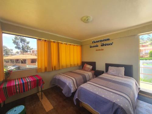 a bedroom with two beds and a window at Kusk'a Lodge in Puno