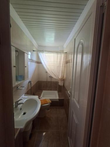 a small bathroom with a sink and a toilet at Hotel Ira in Leptokarya