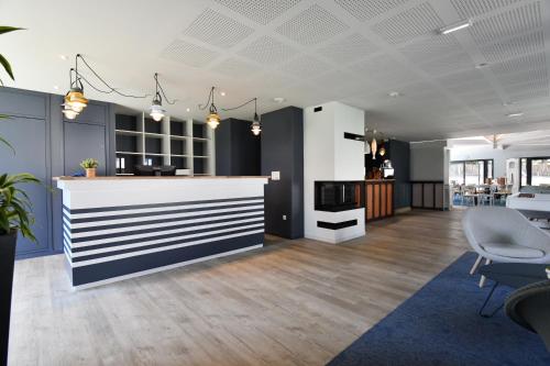 an office lobby with a counter and chairs at Kyriad Lannion-Perros-Guirec in Lannion
