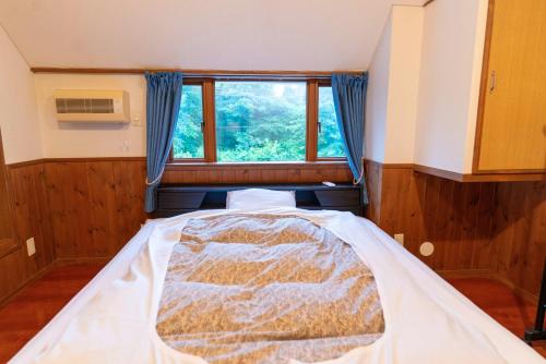 a large bed in a room with a window at 灯ノ環tomonowa in Mitsuwa
