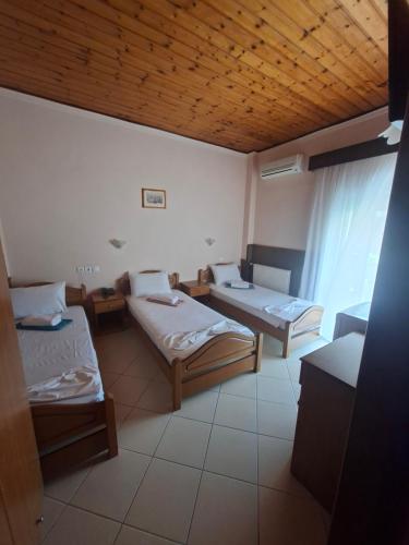 a room with two beds and a window in it at Hotel Ira in Leptokarya