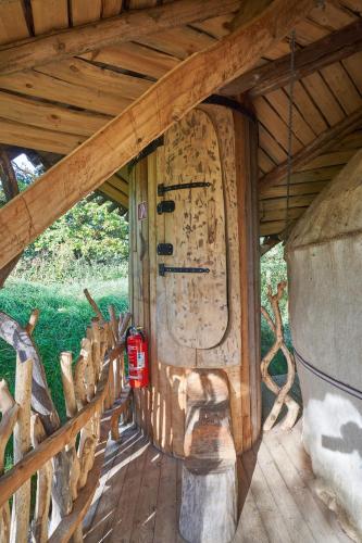 a wooden porch with a door in a building at Baumhaushotel - Die geheime Welt von Turisede - Kulturinsel Einsiedel in Zentendorf