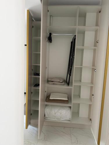 a walk in closet with white cabinets and shelves at Elegant & cozy NeSt in Chiajna
