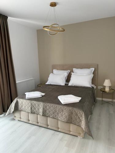 a bedroom with a large bed with white pillows at Elegant & cozy NeSt in Chiajna