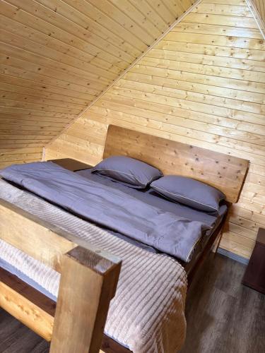 a bed in a wooden room in a cabin at Lake Tsover in Dsegh