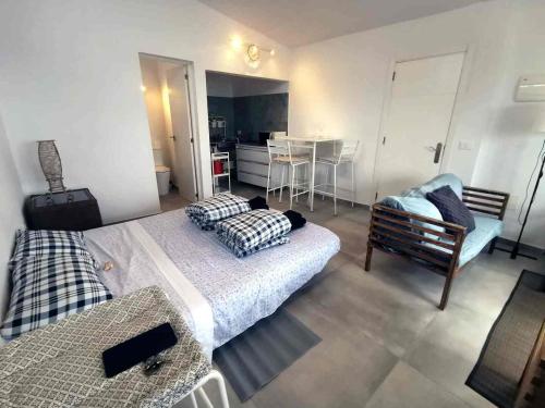 a bedroom with two beds and a kitchen and a table at Ocean front La Maresia Holiday 2 Apartments in Taganana