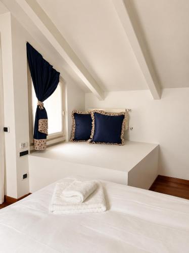 a bedroom with a bed with blue pillows and a window at La Villa Del Parco in Monza