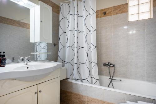 a bathroom with a sink and a shower curtain at Pallantides Residence in Pallini