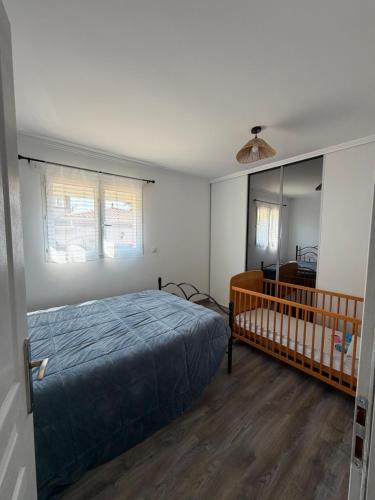 a bedroom with a bed and a crib in it at Location Vias in Vias
