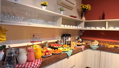 ein Buffet mit Speisen und Getränken an einer Theke in der Unterkunft Domus Hotel Cidade Nobre - Ipatinga in Ipatinga