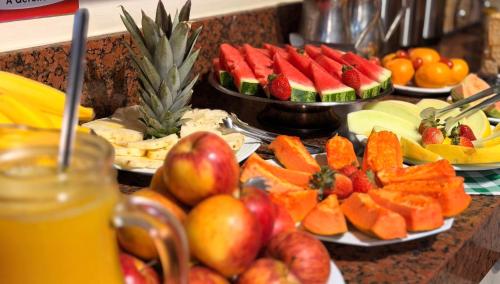 ein Buffet mit Obst und Gemüse auf Tellern auf einer Theke in der Unterkunft Domus Hotel Cidade Nobre - Ipatinga in Ipatinga