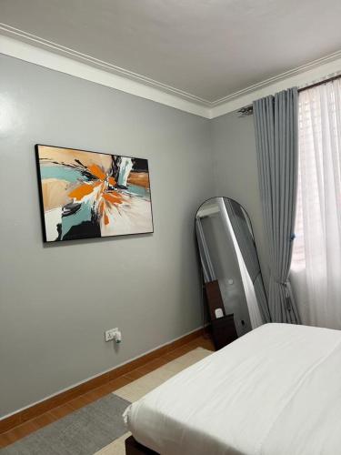 a bedroom with a bed and a painting on the wall at Ssentongo Properties Limited in Kampala