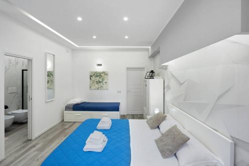 a white and blue bedroom with a blue bed at Secretum Pompeii House in Pompei