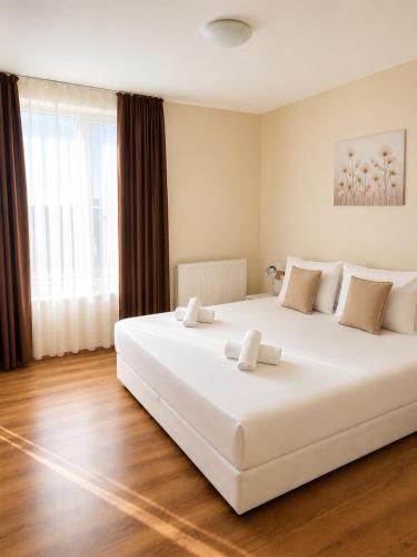 a large white bed in a room with a large window at Villa Eloris in Pismenovo