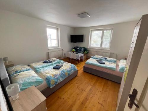 a bedroom with two beds and a flat screen tv at Chalupa u Tomáša in Lúčky