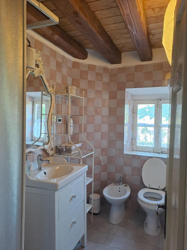 a bathroom with a sink and a toilet and a mirror at Antico Chalet Momosa Maxi in Ovindoli
