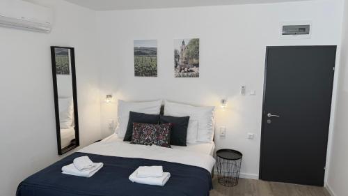 a bedroom with a bed with two towels on it at Natali Apartmanház in Eger