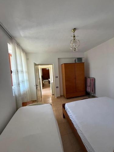 a bedroom with two beds and a chandelier at Villa Balliu in Pogradec