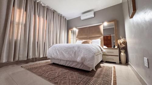 a bedroom with a bed and a large window at Saob Property in Germiston