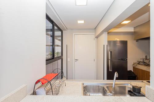 a kitchen with a sink and a refrigerator at One House by Anora Spaces in São Paulo