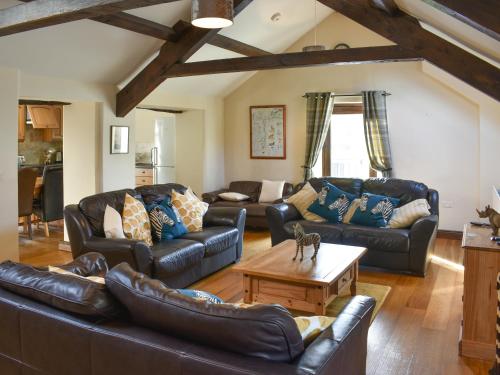 a living room with leather couches and a coffee table at Combe Cottage-Uk42228 in Low Borrowbridge