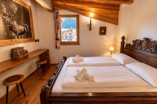 a bedroom with a bed with a wooden headboard at Chalet degli Abeti by AMA Val di Fassa in Campitello di Fassa