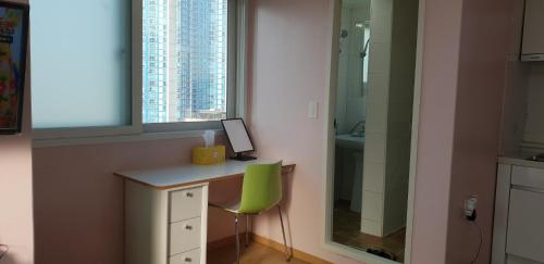 a desk with a green chair next to a window at Namsan Ville in Seoul