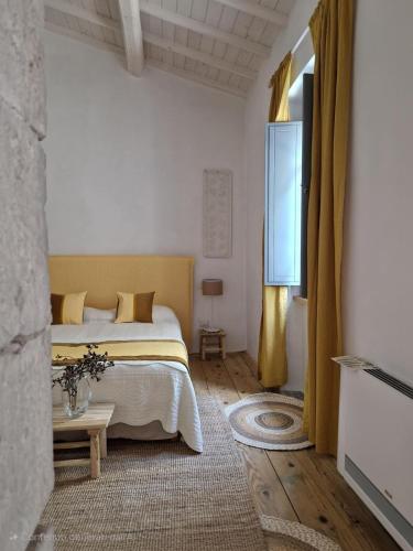 a bedroom with a bed and a table and a window at Casa S'urtzula in Sini