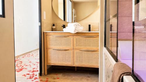 a bathroom with a sink and a mirror at COCON Mayennais - Loft Balnéo Laval in Laval