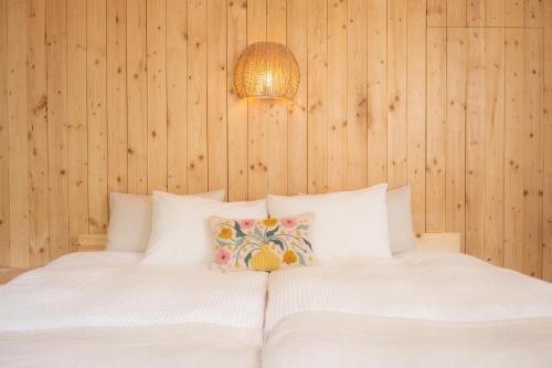 a bedroom with a white bed with wooden walls at Lalafofofo in Biei