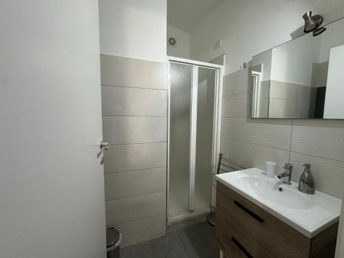 a white bathroom with a sink and a shower at La Casa di Orlando in Catania